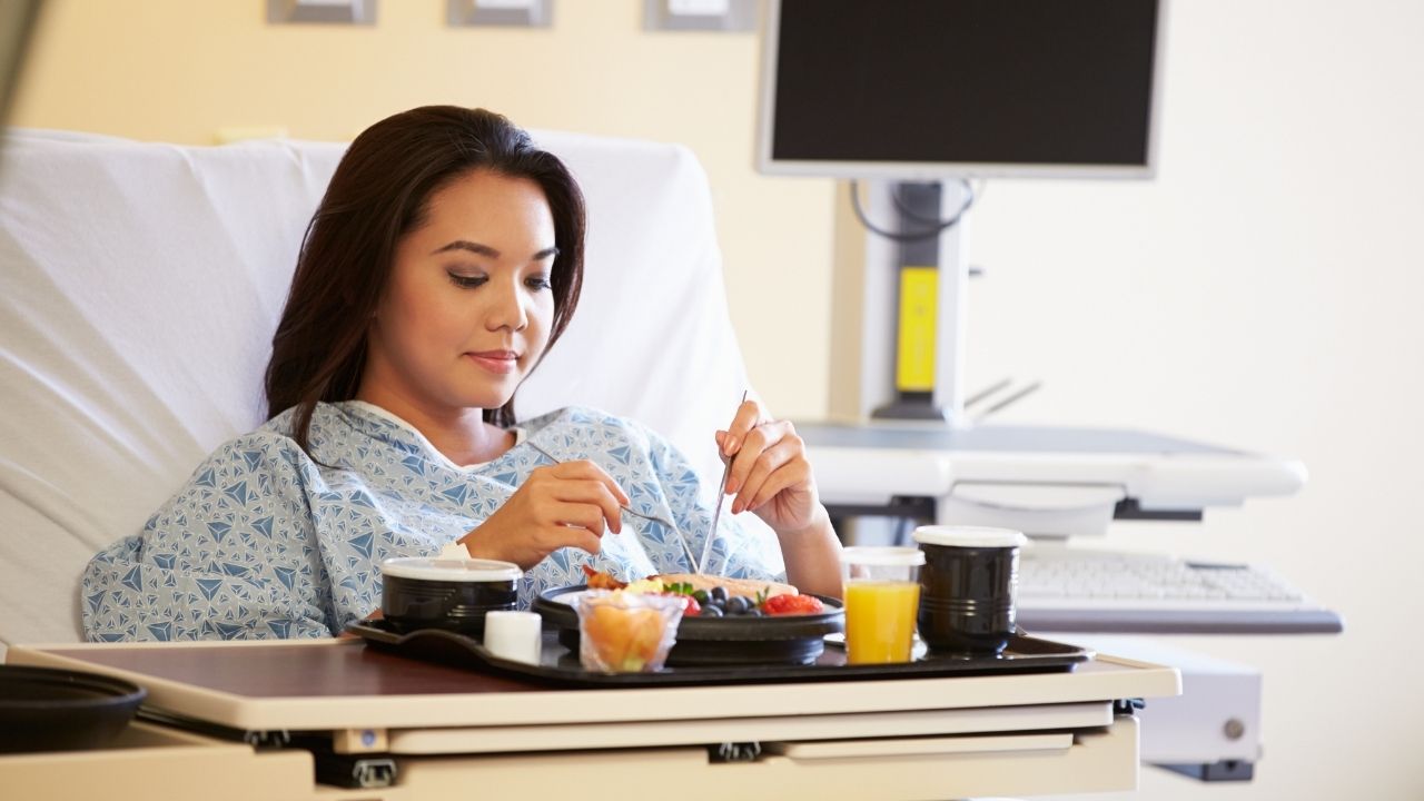 woman in hospital bed eating